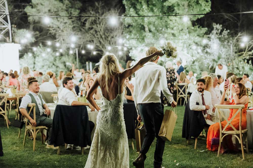 Ceremonia de boda al aire libre de noche con faroles, árboles iluminados y decoración mágica.