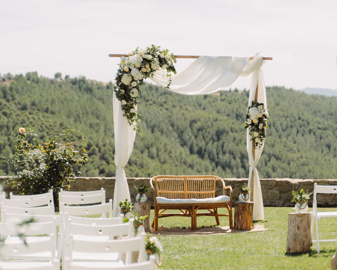 Cerimònia de casament a l’aire lliure, altar decorat amb flors i vistes al bosc, organitza el casament en un entorn natural